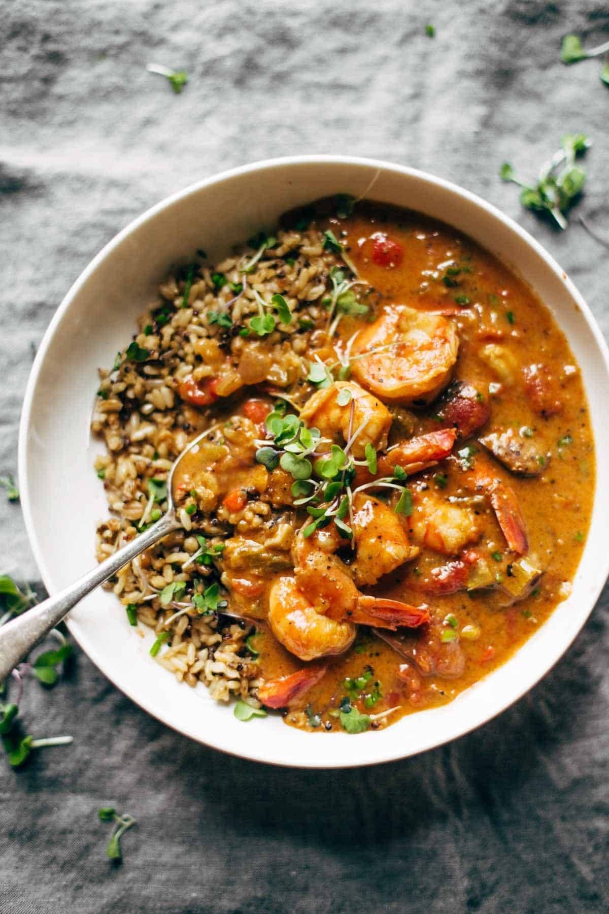 Shrimp and rice on a napkin with a spoon in a bowl.