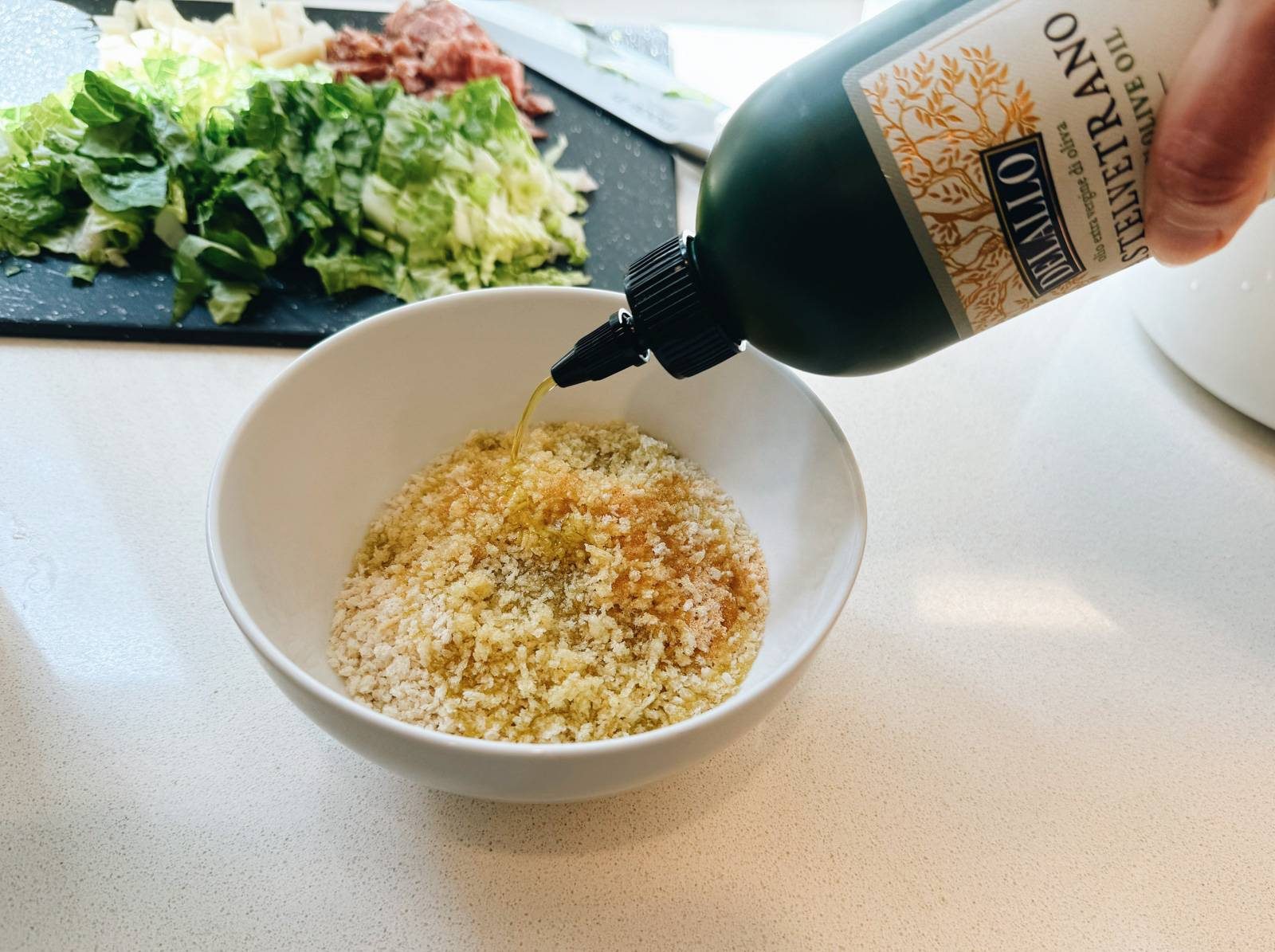 Squeezing olive oil into a bowl of breadcrumbs.