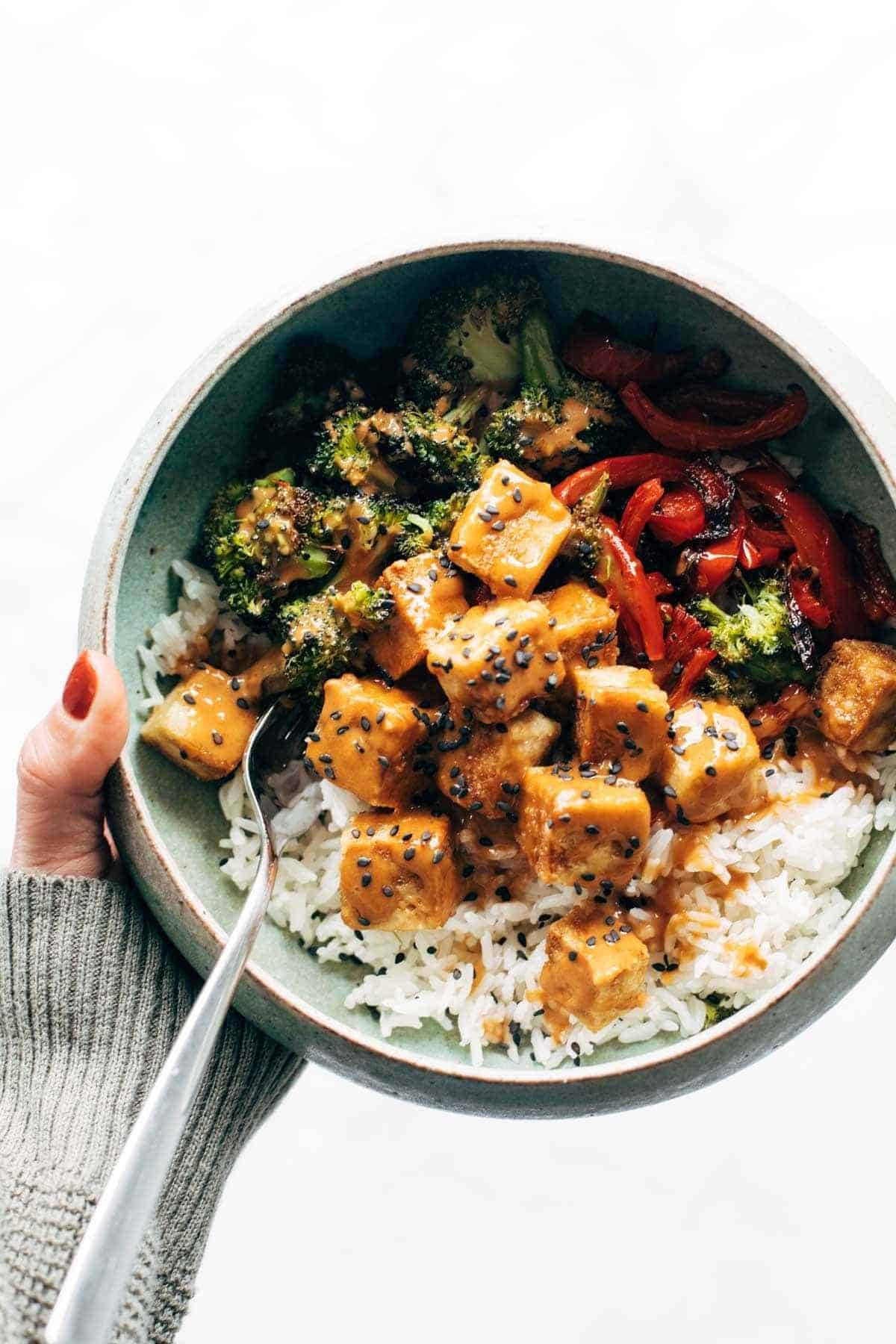 Peanut tofu in a bow with veggies and rice.