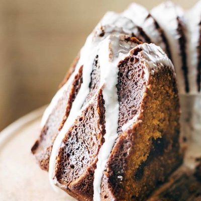 Pumpkin Bundt Cake on cake stand with glaze.