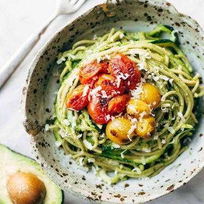 Zucchini Spaghetti with Avocado Sauce in a bowl with tomatoes.