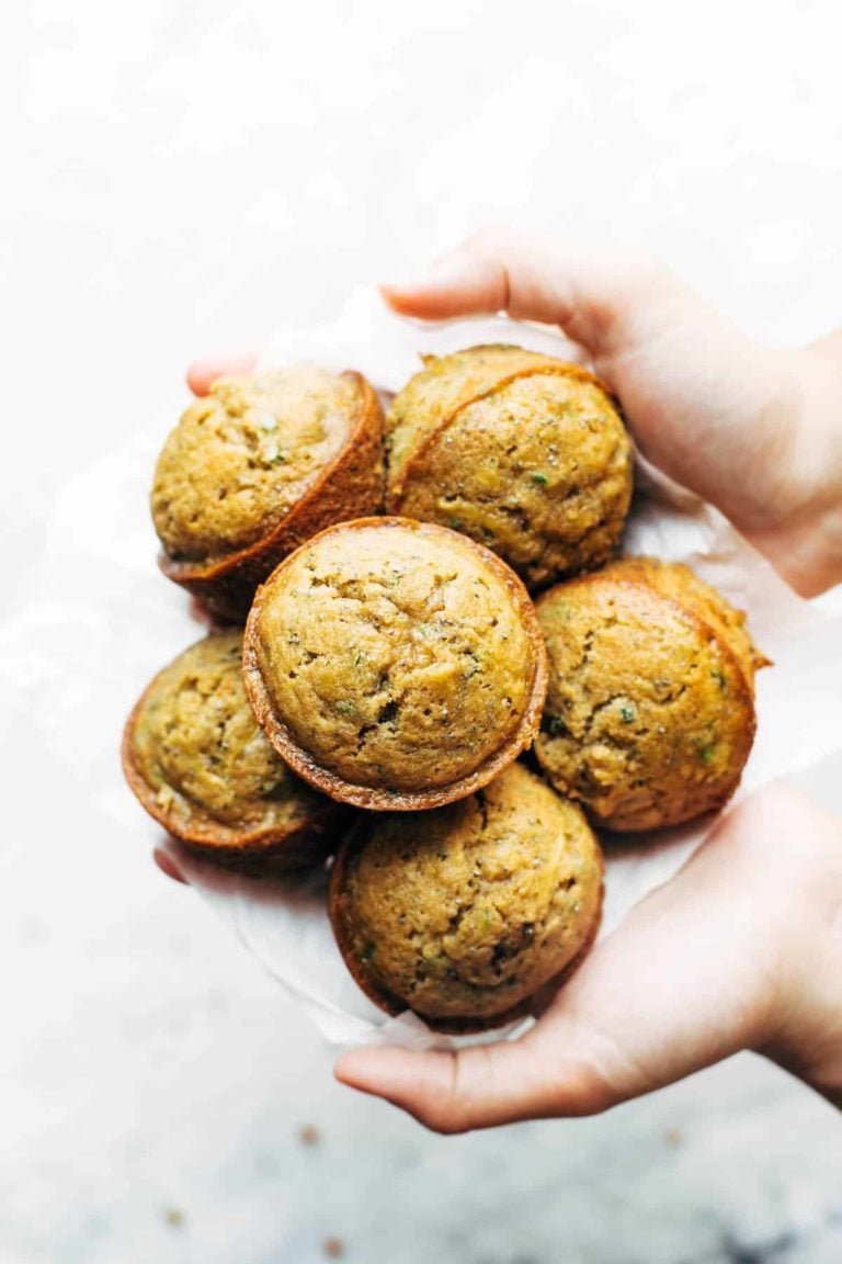 Hands holding lemon poppyseed zucchini muffins.