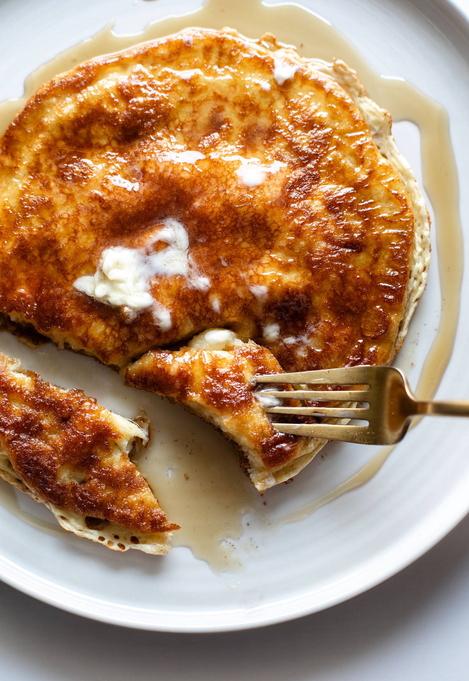 Cottage cheese pancake on a plate with butter and syrup.