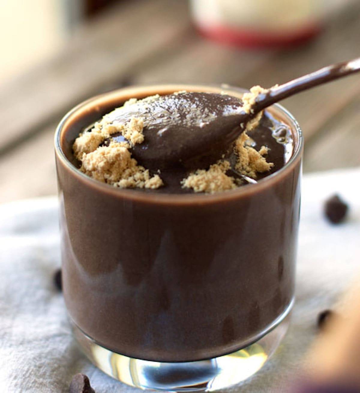 Double chocolate malt bananas, tofu, almond milk, and cocoa in a glass with a spoon.