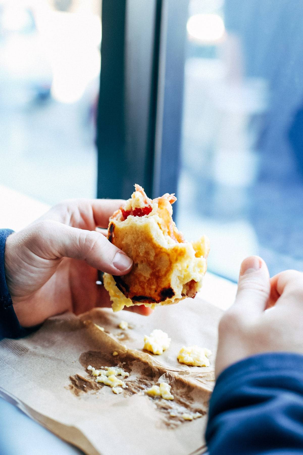Hands holding a sandwich.